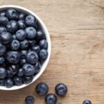 blueberries in a bowl on a wooden table